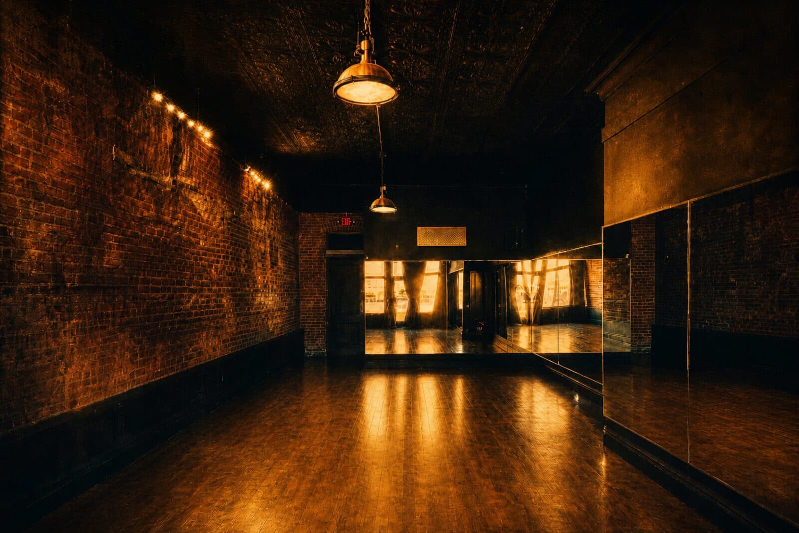 The Greenroom studio interior — brick walls, brass pendant lamps, mirrored wall and polished wood floor, rendered as a moody fine-art print